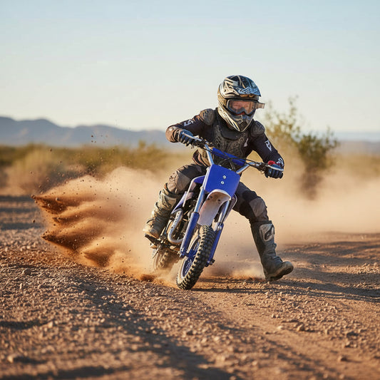 Kid riding a blue pit bike wearing full protective motocross gear, helmet, and boots.