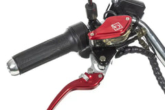 Close-up of motorcycle handlebar with red brake lever and black grip