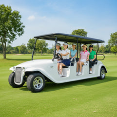 White vintage-style 6-seater electric golf cart carrying passengers on a green golf course.