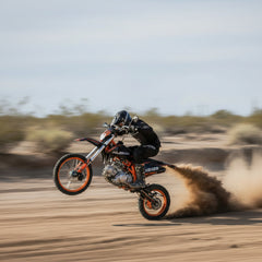Person riding a dirt bike on a sandy track