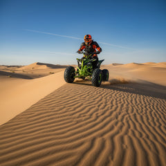 Person riding a green ATV in the desert
