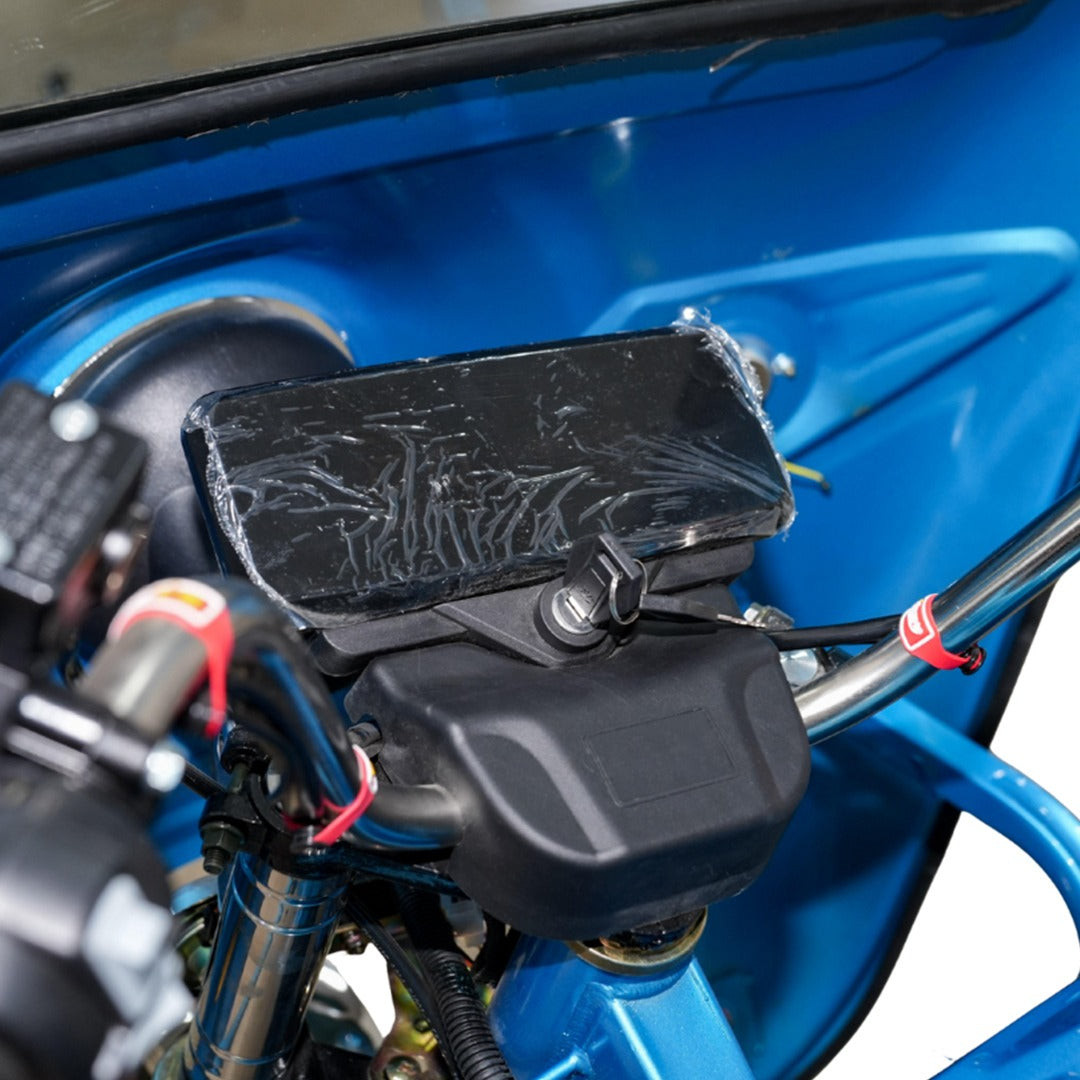 Close-up of a blue motorcycle with an LCD Display on the handlebars.